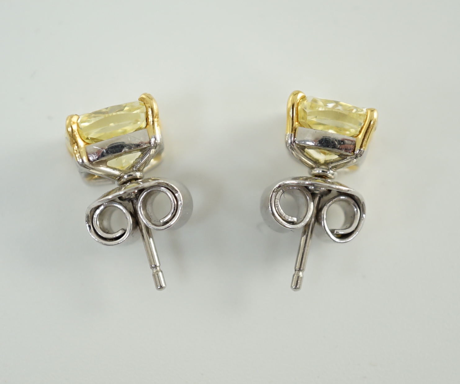 A fine pair of Graf platinum and 18ct white gold set cushion modified brilliant cut natural fancy yellow diamond ear studs